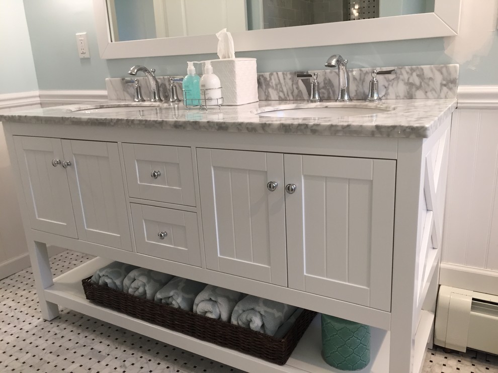 Réalisation d'une salle de bain design de taille moyenne avec des portes de placard blanches, un mur bleu, un lavabo encastré et un plan de toilette en marbre.