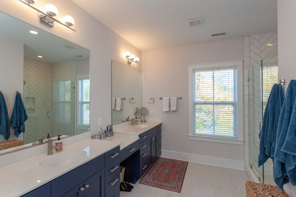 This is an example of a large beach style ensuite bathroom in Charleston with shaker cabinets, blue cabinets, metro tiles, mosaic tile flooring, white worktops, a corner shower, white tiles, grey walls, an integrated sink, engineered stone worktops, white floors and a hinged door.