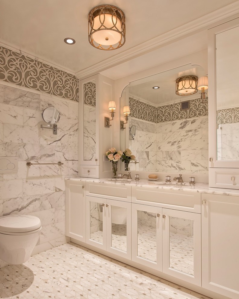Ejemplo de cuarto de baño tradicional con lavabo bajoencimera, armarios tipo vitrina, puertas de armario blancas, sanitario de pared y paredes blancas