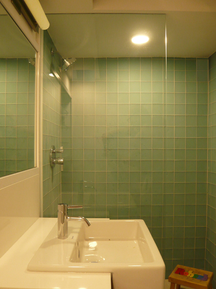 Exempel på ett mellanstort modernt vit vitt badrum för barn, med en dusch i en alkov, grön kakel, glaskakel, gröna väggar, ett integrerad handfat, bänkskiva i akrylsten och med dusch som är öppen