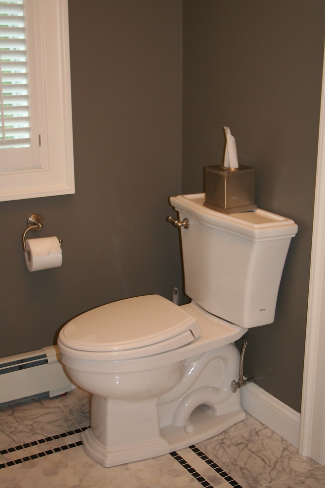 Cette image montre un grand WC et toilettes traditionnel avec un placard à porte shaker, des portes de placard blanches, un plan de toilette en marbre, un carrelage gris, des carreaux de porcelaine, WC séparés, un lavabo encastré, un mur gris et un sol en marbre.