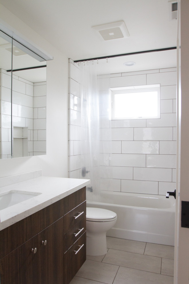 Стильный дизайн: ванная комната в стиле модернизм с темными деревянными фасадами, ванной в нише, душем над ванной, белой плиткой, керамической плиткой, белыми стенами, врезной раковиной, серым полом, шторкой для ванной и белой столешницей - последний тренд