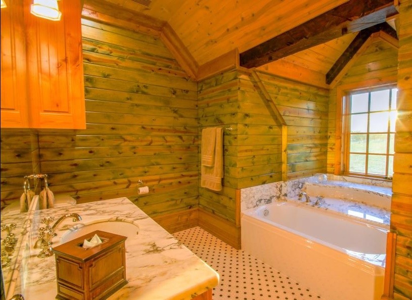 Réalisation d'une grande douche en alcôve principale chalet en bois clair avec une baignoire en alcôve, un mur marron, un lavabo encastré, un plan de toilette en marbre, un placard à porte shaker, WC séparés, un carrelage gris, un carrelage blanc, des dalles de pierre, un sol multicolore et une cabine de douche à porte battante.