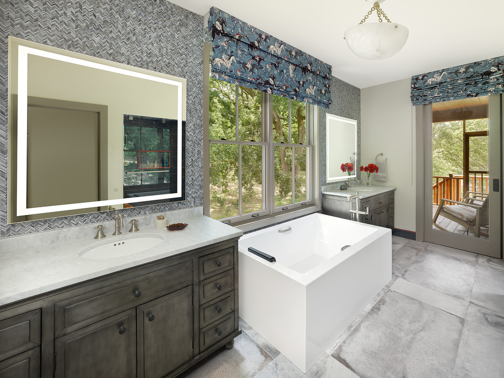 Mid-sized southwest master blue tile and glass tile porcelain tile and blue floor bathroom photo in Dallas with furniture-like cabinets, gray cabinets, a one-piece toilet, beige walls, an undermount sink, marble countertops, a hinged shower door and white countertops