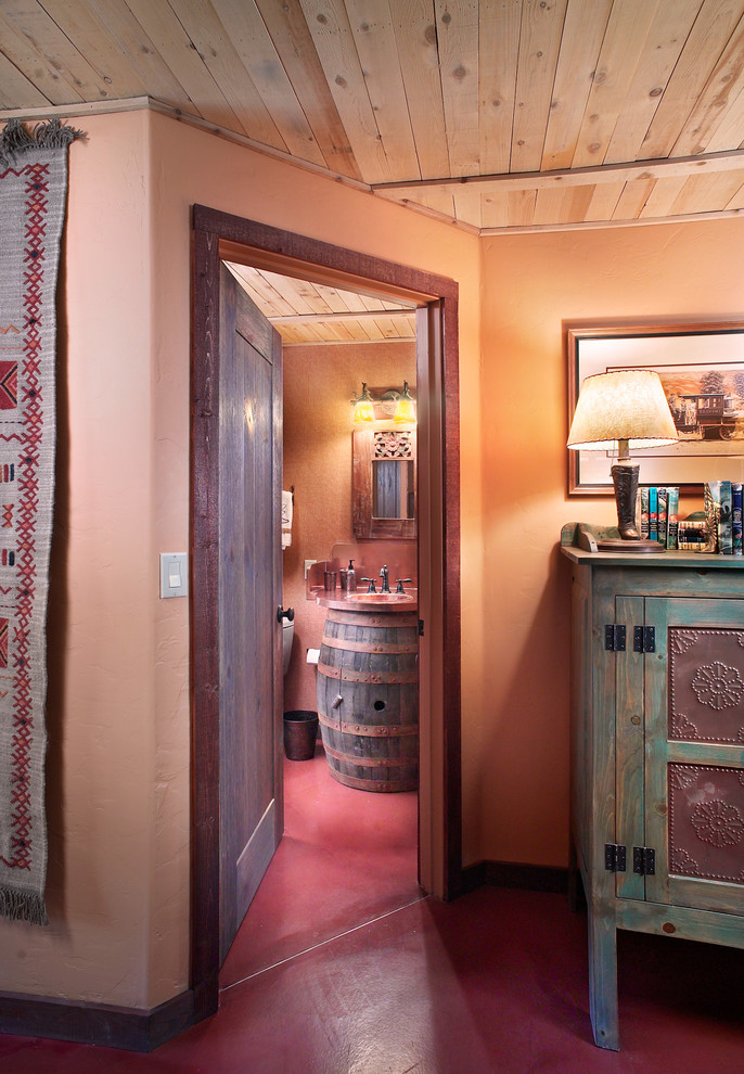 На фото: ванная комната в стиле фьюжн с монолитной раковиной, фасадами островного типа, темными деревянными фасадами, столешницей из меди, оранжевыми стенами, бетонным полом и душевой кабиной с