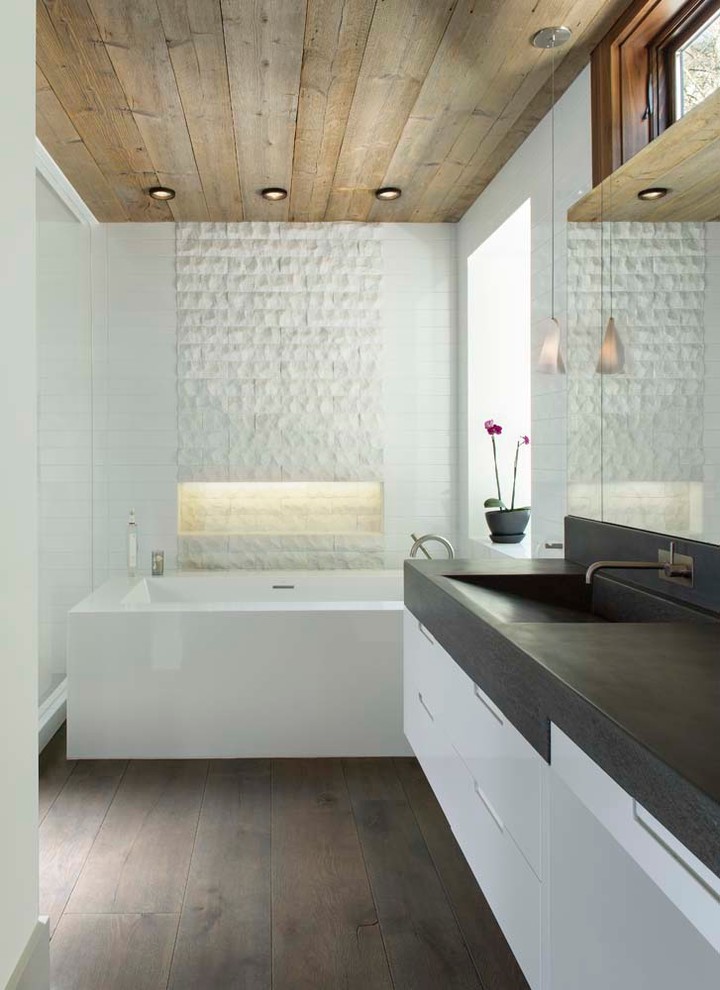 Modern inredning av ett mellanstort en-suite badrum, med vit kakel, vita väggar och ljust trägolv