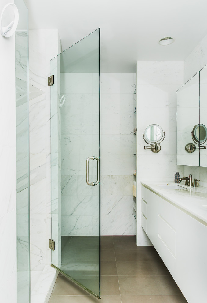 Идея дизайна: ванная комната среднего размера в современном стиле с фасадами с выступающей филенкой, белыми фасадами, душем в нише, унитазом-моноблоком, белой плиткой, плиткой из листового камня, белыми стенами, полом из керамической плитки, душевой кабиной, врезной раковиной и мраморной столешницей