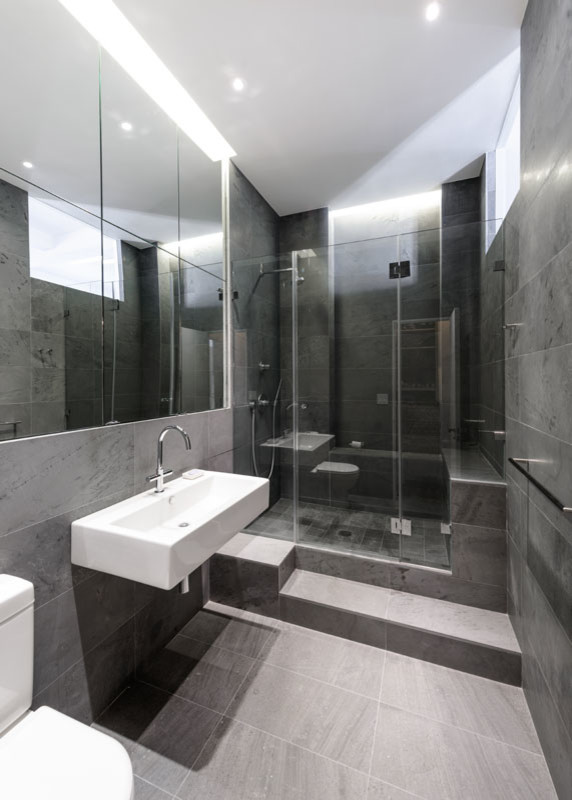 На фото: главная ванная комната среднего размера в современном стиле с душем в нише, раздельным унитазом, серой плиткой, каменной плиткой, серыми стенами, полом из сланца и подвесной раковиной с