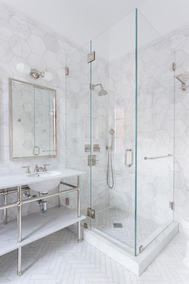 Medium sized contemporary ensuite bathroom in New York with a built-in sink, marble worktops, a corner shower, white tiles, ceramic tiles, white walls, ceramic flooring, a freestanding bath and a hinged door.