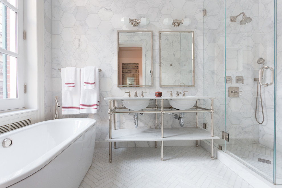 This is an example of a medium sized traditional ensuite bathroom in New York with marble worktops, a freestanding bath, a corner shower, white tiles, ceramic tiles, ceramic flooring, a console sink, white walls and a hinged door.