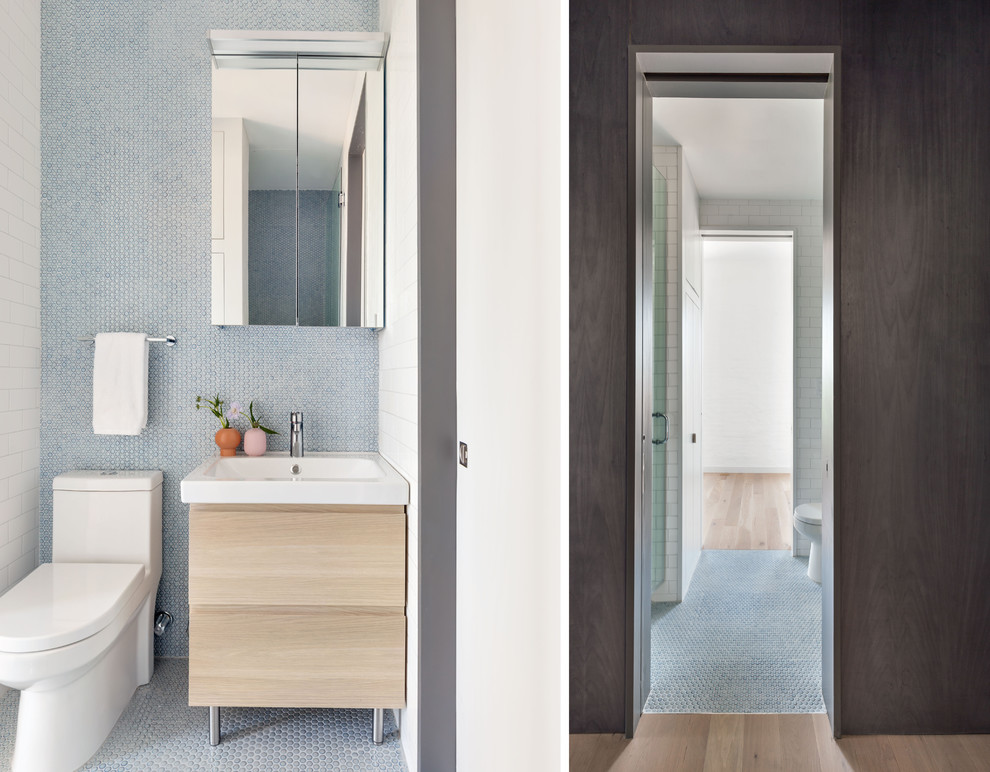 ニューヨークにあるお手頃価格の小さなコンテンポラリースタイルのおしゃれな浴室 (淡色木目調キャビネット、アルコーブ型シャワー、青いタイル、サブウェイタイル、人工大理石カウンター、白い洗面カウンター) の写真