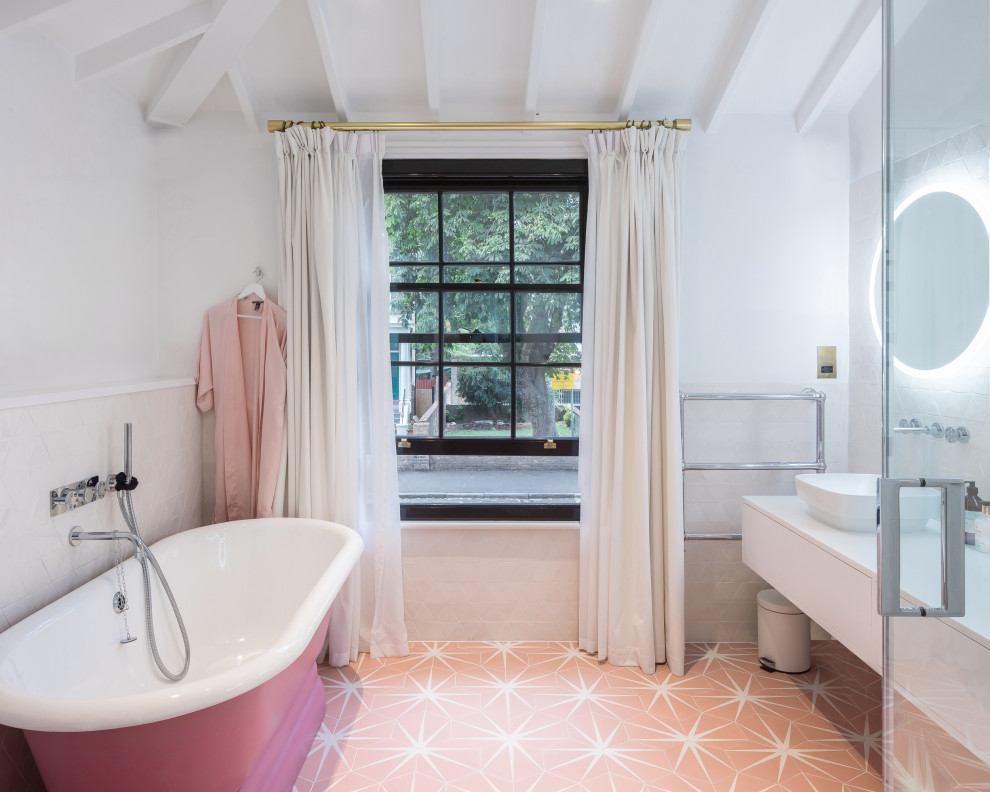 Example of a transitional 3/4 pink floor, single-sink, exposed beam and vaulted ceiling freestanding bathtub design in London with flat-panel cabinets, white cabinets, white walls, white countertops and a floating vanity