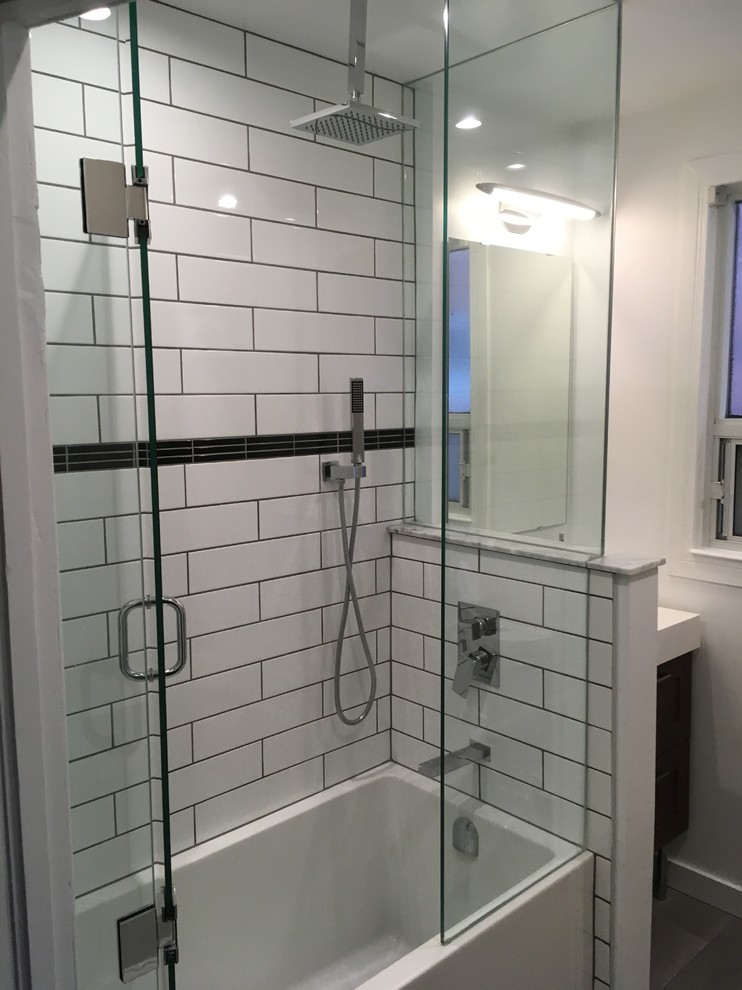 Kleines Modernes Badezimmer mit braunen Schränken, Badewanne in Nische, Duschbadewanne, weißen Fliesen, Porzellanfliesen, weißer Wandfarbe, integriertem Waschbecken und Falttür-Duschabtrennung in Toronto
