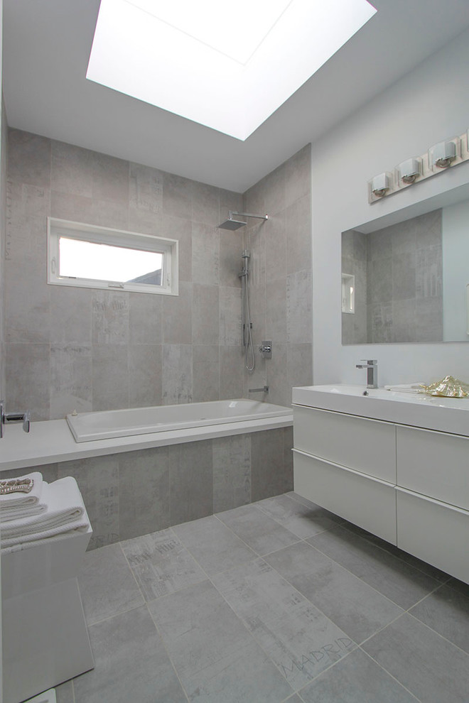 Kleines Nordisches Badezimmer En Suite mit integriertem Waschbecken, flächenbündigen Schrankfronten, weißen Schränken, Einbaubadewanne, Keramikfliesen, weißer Wandfarbe und hellem Holzboden in Toronto