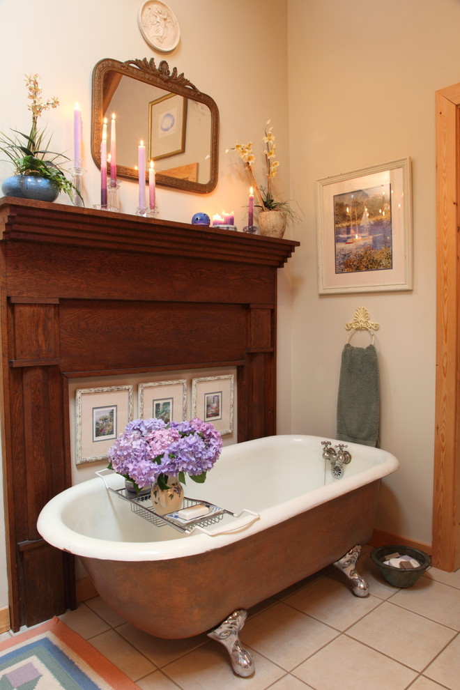 На фото: ванная комната в стиле рустика с ванной на ножках с