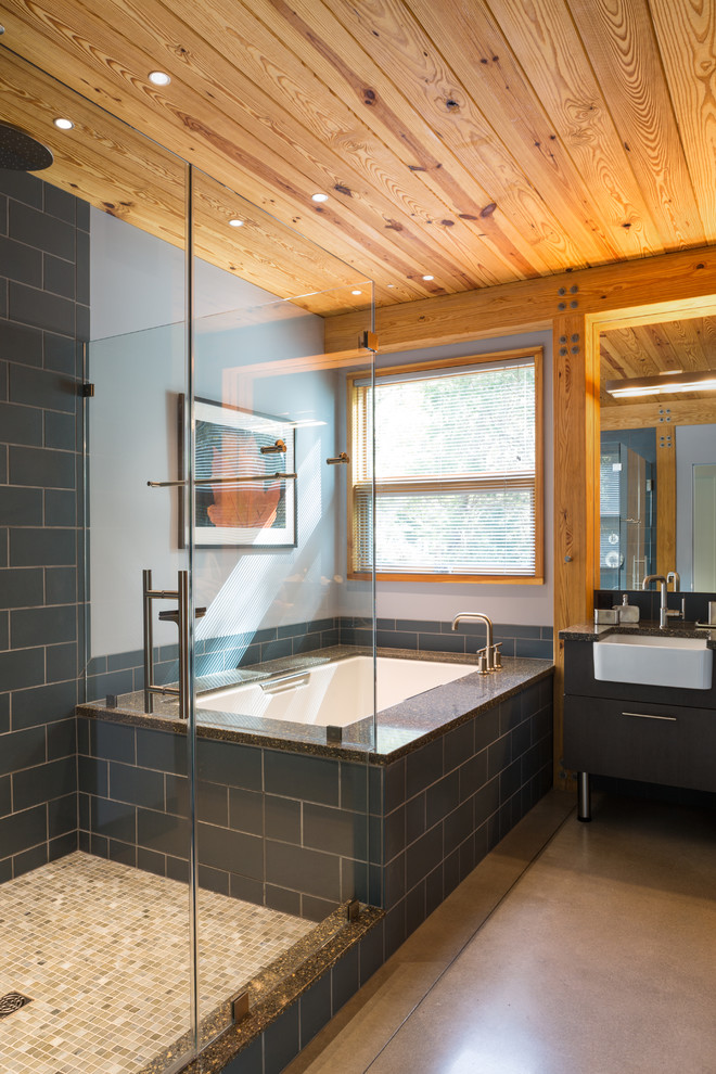 Idéer för mellanstora funkis en-suite badrum, med släta luckor, grå skåp, ett undermonterat badkar, en hörndusch, grå kakel, porslinskakel, grå väggar, betonggolv, brunt golv och dusch med gångjärnsdörr
