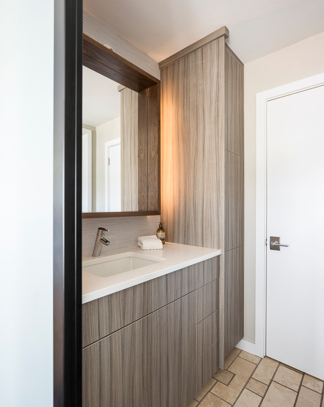 Modelo de cuarto de baño moderno pequeño con lavabo bajoencimera, armarios con paneles lisos, puertas de armario marrones, baldosas y/o azulejos beige, paredes beige y aseo y ducha