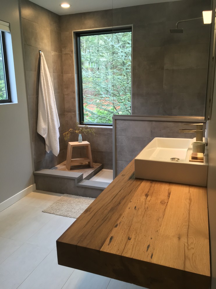 Design ideas for a medium sized contemporary ensuite bathroom in New York with an alcove shower, grey walls, a vessel sink and wooden worktops.