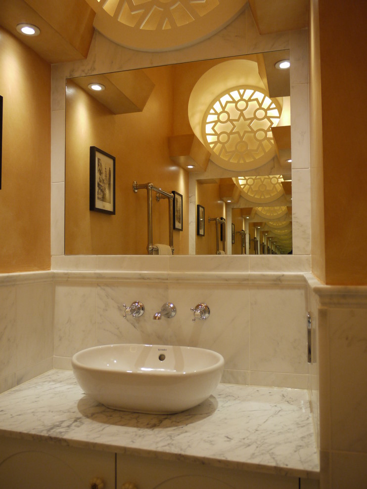 Inspiration för mellanstora eklektiska en-suite badrum, med ett fristående handfat, möbel-liknande, vita skåp, marmorbänkskiva, ett fristående badkar, en dusch i en alkov, en vägghängd toalettstol, vit kakel, stenhäll, gula väggar och kalkstensgolv