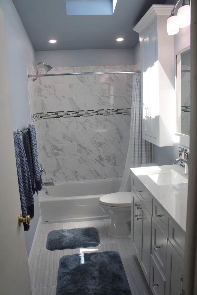 Example of a mid-sized classic master black and white tile and ceramic tile ceramic tile, gray floor, double-sink and vaulted ceiling bathroom design in Baltimore with recessed-panel cabinets, white cabinets, a two-piece toilet, blue walls, an undermount sink, granite countertops, white countertops and a built-in vanity