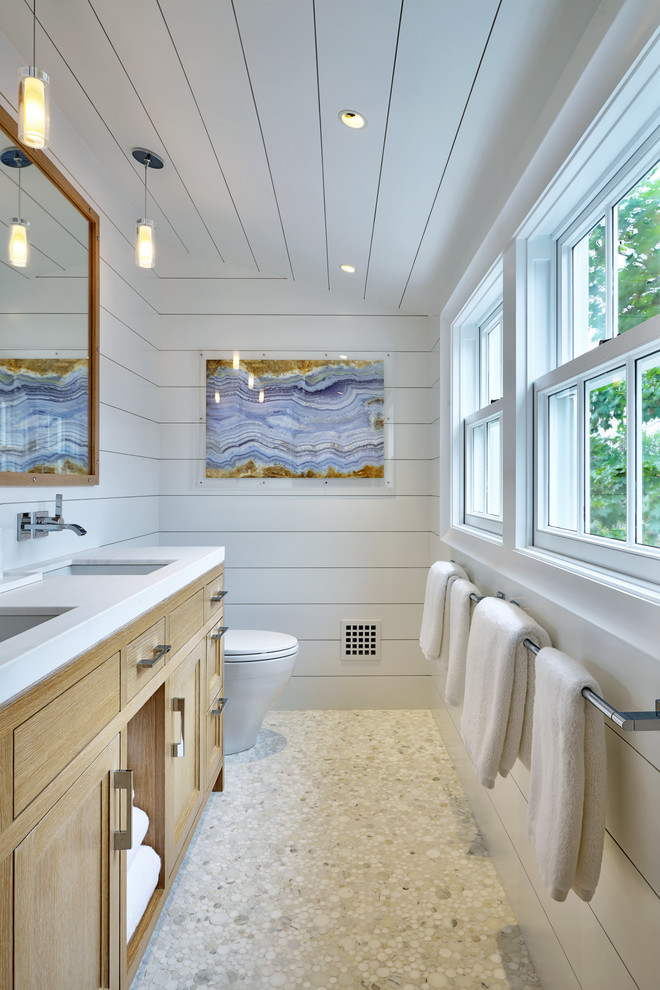 Стильный дизайн: ванная комната в морском стиле с фасадами с декоративным кантом, коричневыми фасадами, белыми стенами, полом из галечной плитки и врезной раковиной - последний тренд