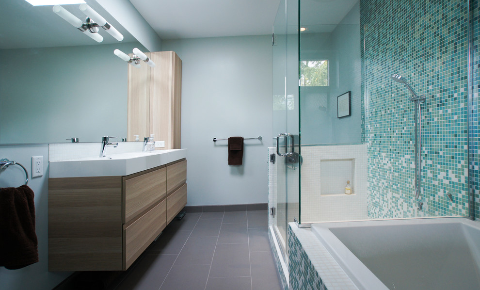 Réalisation d'une grande douche en alcôve principale design en bois clair avec un lavabo intégré, une baignoire d'angle, un carrelage bleu, un mur bleu, mosaïque, un placard à porte plane, WC à poser, un sol en carrelage de porcelaine et un plan de toilette en quartz modifié.