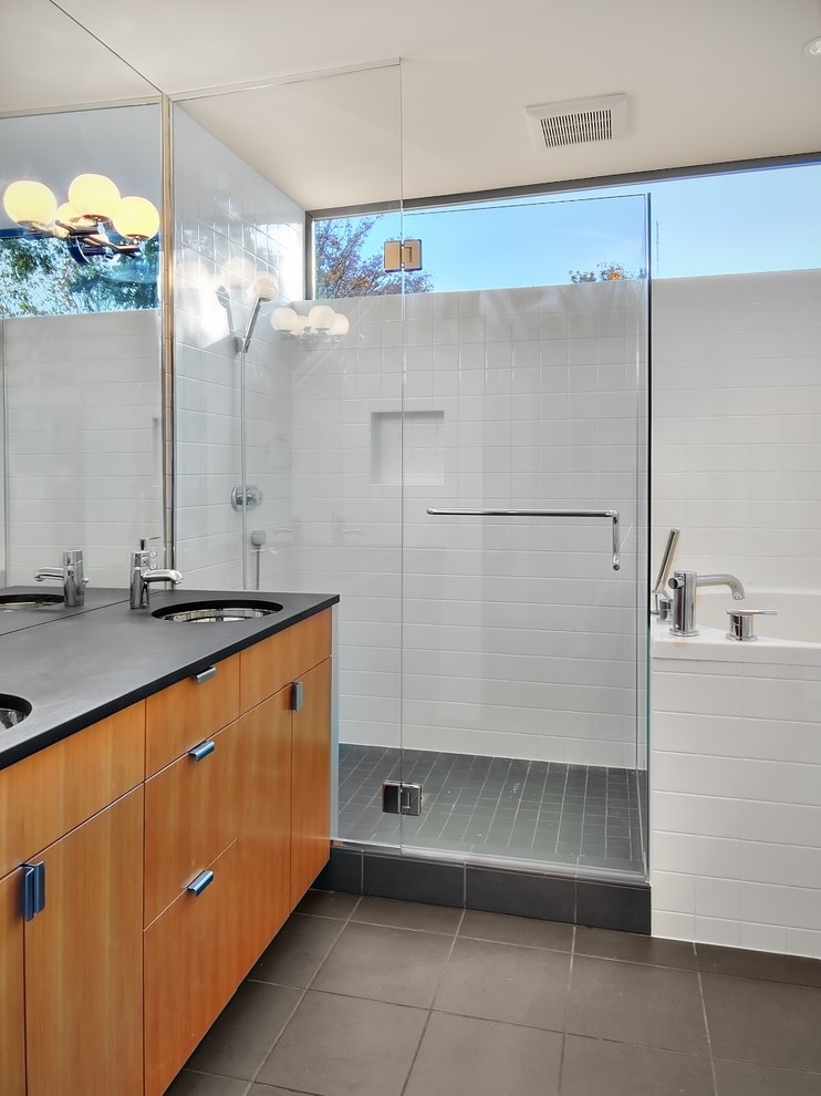 На фото: ванная комната в современном стиле с врезной раковиной, плоскими фасадами, фасадами цвета дерева среднего тона, японской ванной, угловым душем, белой плиткой и окном