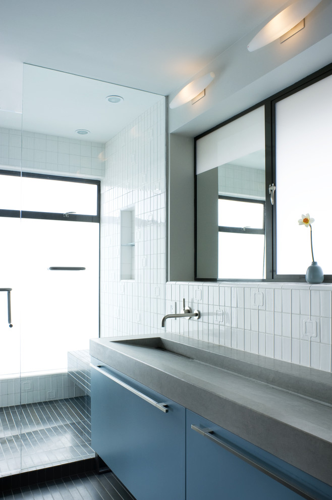 Diseño de cuarto de baño minimalista con lavabo integrado y puertas de armario azules