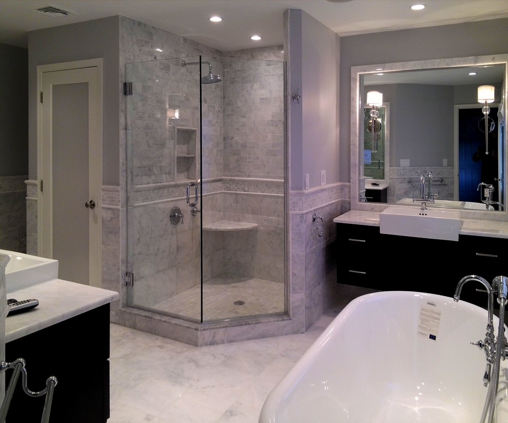 Design ideas for a large contemporary ensuite bathroom in Philadelphia with a trough sink, recessed-panel cabinets, dark wood cabinets, marble worktops, a freestanding bath, a corner shower, a one-piece toilet, white tiles, stone tiles, grey walls, marble flooring, white floors and a hinged door.