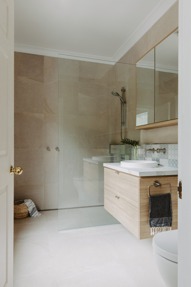 Inspiration för mellanstora moderna vitt badrum med dusch, med släta luckor, skåp i ljust trä, en kantlös dusch, beige kakel, ett nedsänkt handfat, beiget golv och med dusch som är öppen
