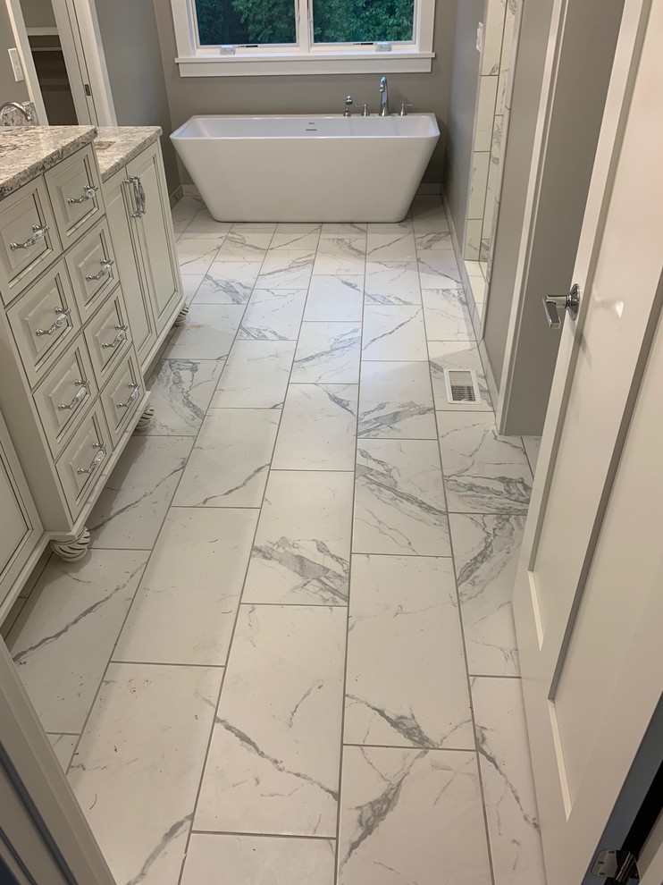 Esempio di una stanza da bagno padronale eclettica di medie dimensioni con ante bianche, vasca freestanding, pavimento in gres porcellanato e pavimento bianco