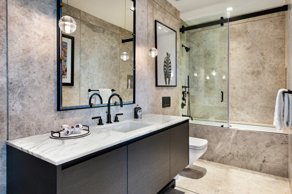 Modern inredning av ett vit vitt badrum, med släta luckor, svarta skåp, ett badkar i en alkov, en dusch/badkar-kombination, grå kakel, ett undermonterad handfat, grått golv och dusch med skjutdörr