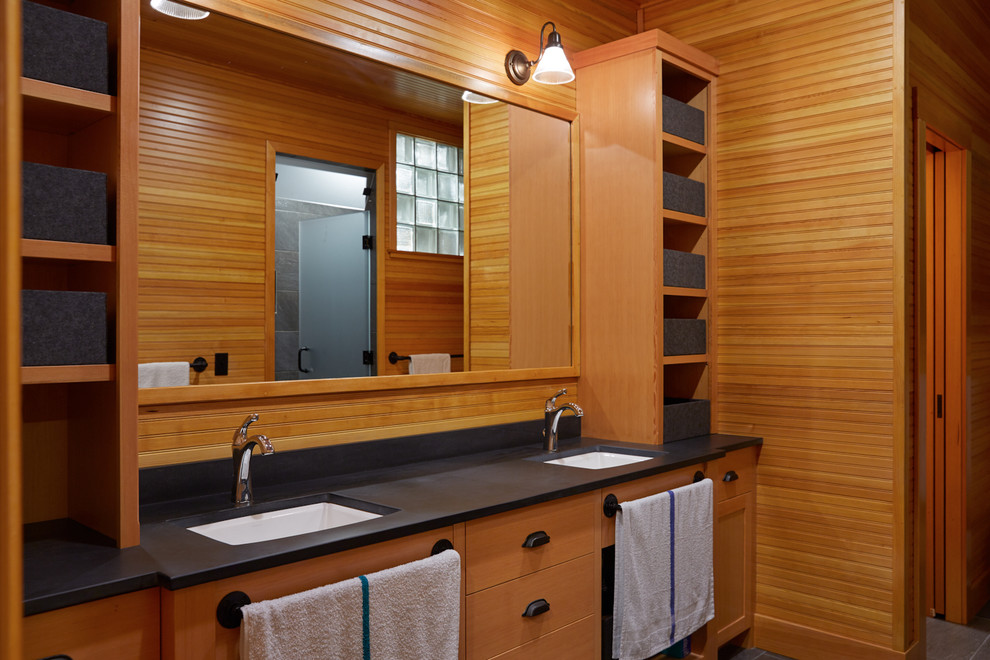 This is an example of a large rustic ensuite bathroom in Portland Maine with a submerged sink, raised-panel cabinets, light wood cabinets, a corner bath, a walk-in shower, a one-piece toilet, grey tiles, stone tiles, beige walls, ceramic flooring and solid surface worktops.