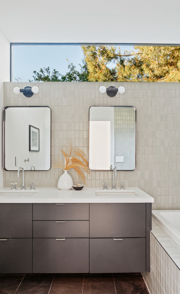 Идея дизайна: главная ванная комната в современном стиле с плоскими фасадами, серыми фасадами, накладной ванной, серой плиткой, белыми стенами, врезной раковиной, коричневым полом и белой столешницей