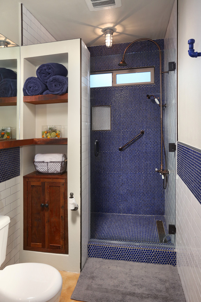 Inredning av ett klassiskt mellanstort badrum med dusch, med en dusch i en alkov, en toalettstol med separat cisternkåpa, blå kakel, mosaik, ett väggmonterat handfat, skåp i shakerstil, skåp i mörkt trä, vita väggar och dusch med gångjärnsdörr
