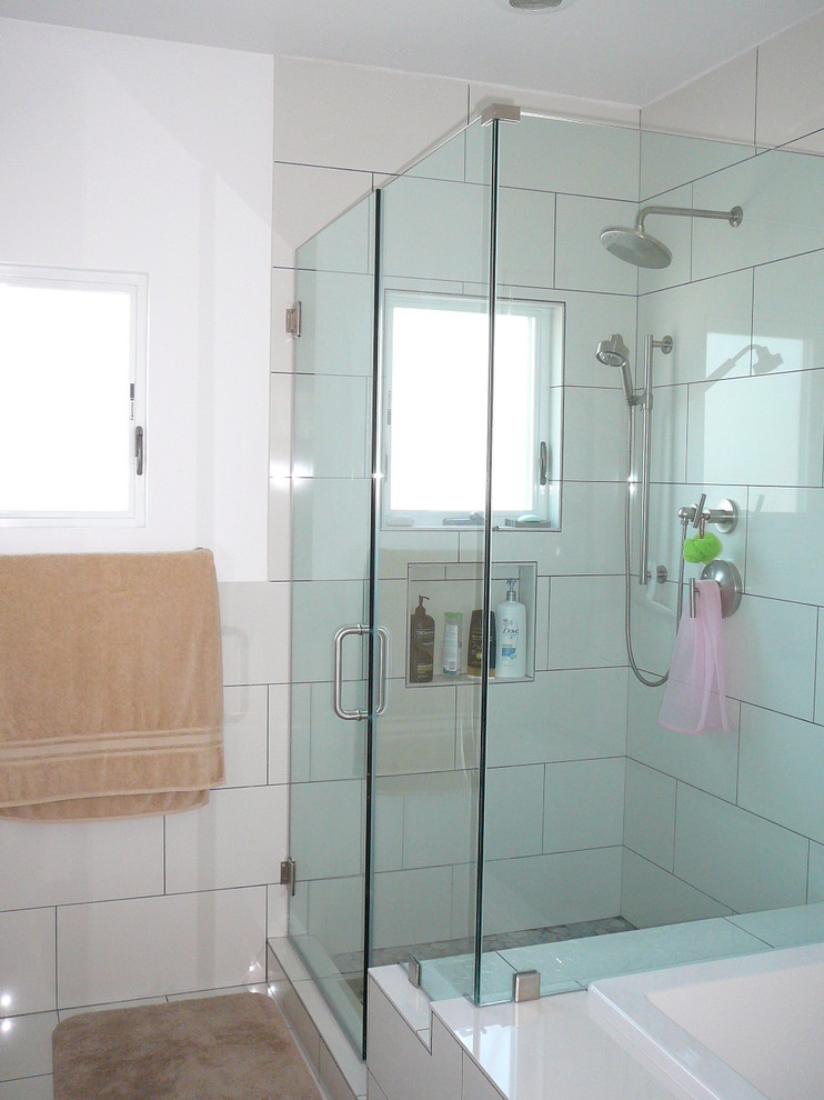Cette photo montre une salle de bain principale moderne en bois foncé de taille moyenne avec une baignoire posée, une douche d'angle, WC à poser, un carrelage blanc, des carreaux de porcelaine, un mur blanc, un sol en carrelage de porcelaine et un lavabo suspendu.