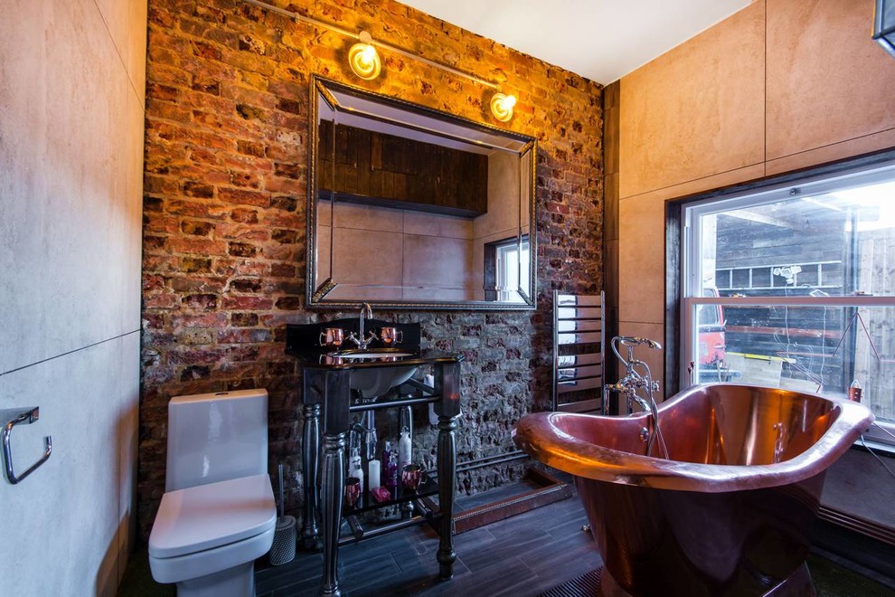 ロンドンにある小さなインダストリアルスタイルのおしゃれな浴室 (一体型トイレ	、ベージュの壁、アンダーカウンター洗面器、黒い床) の写真