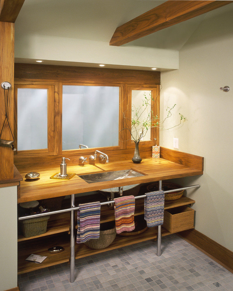 Imagen de cuarto de baño ecléctico con encimera de madera