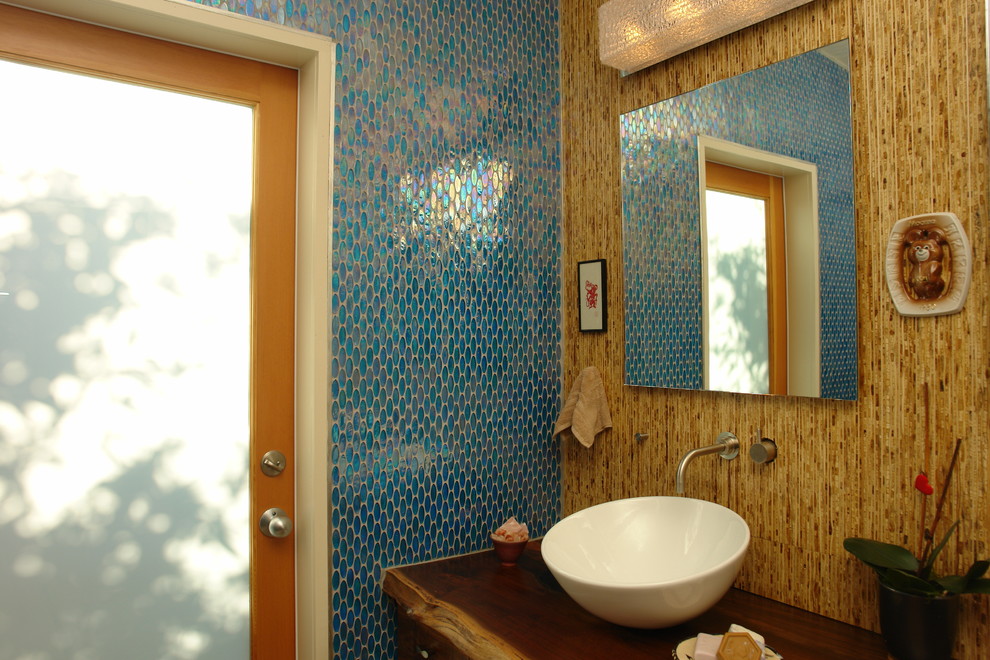 Ispirazione per una grande stanza da bagno padronale tropicale con lavabo a bacinella, top in legno, piastrelle blu, piastrelle di vetro, pareti marroni, ante in legno bruno, ante lisce e pavimento con piastrelle di ciottoli