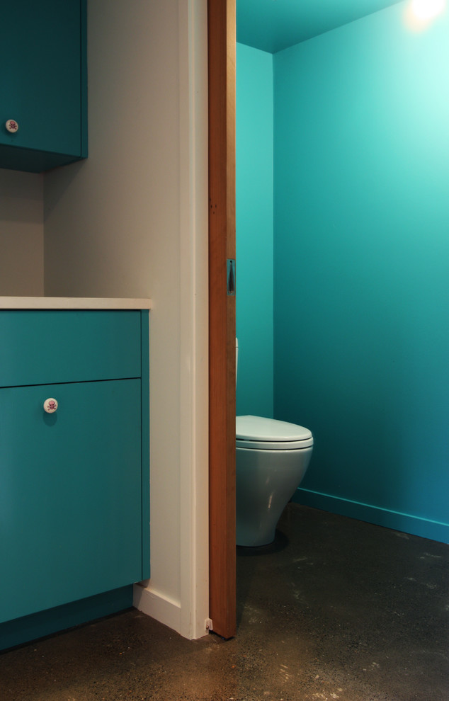 Foto di una stanza da bagno con doccia eclettica di medie dimensioni con ante lisce, ante blu, WC monopezzo, piastrelle grigie, pareti bianche, pavimento in cemento e top in quarzite