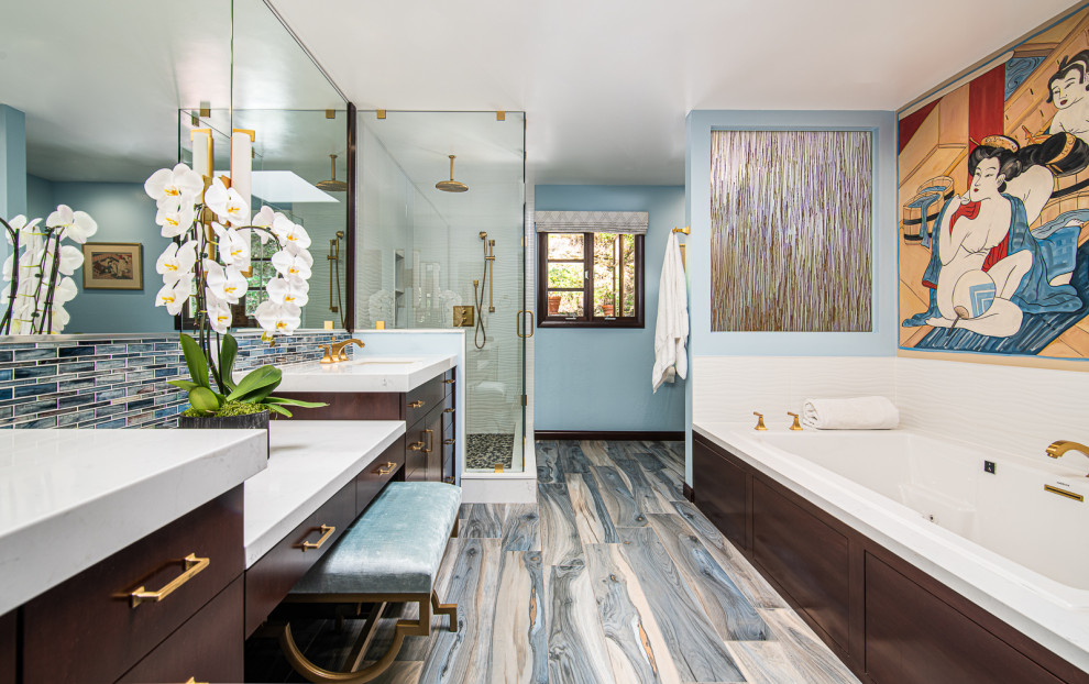 Mid-sized transitional master white tile and porcelain tile medium tone wood floor and multicolored floor bathroom photo in Los Angeles with glass-front cabinets, dark wood cabinets, blue walls, an undermount sink, quartz countertops, a hinged shower door and white countertops