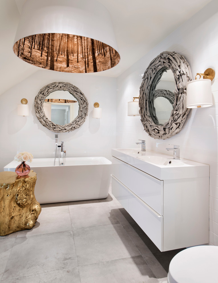Mid-sized eclectic white tile marble floor freestanding bathtub photo in Ottawa with white cabinets, a one-piece toilet and white walls