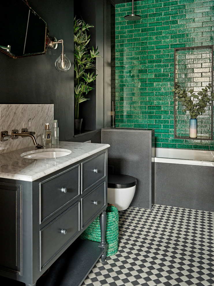 Aménagement d'une salle d'eau classique avec des portes de placard grises, une baignoire posée, un combiné douche/baignoire, un carrelage vert, un mur gris, un lavabo encastré, un sol multicolore et aucune cabine.