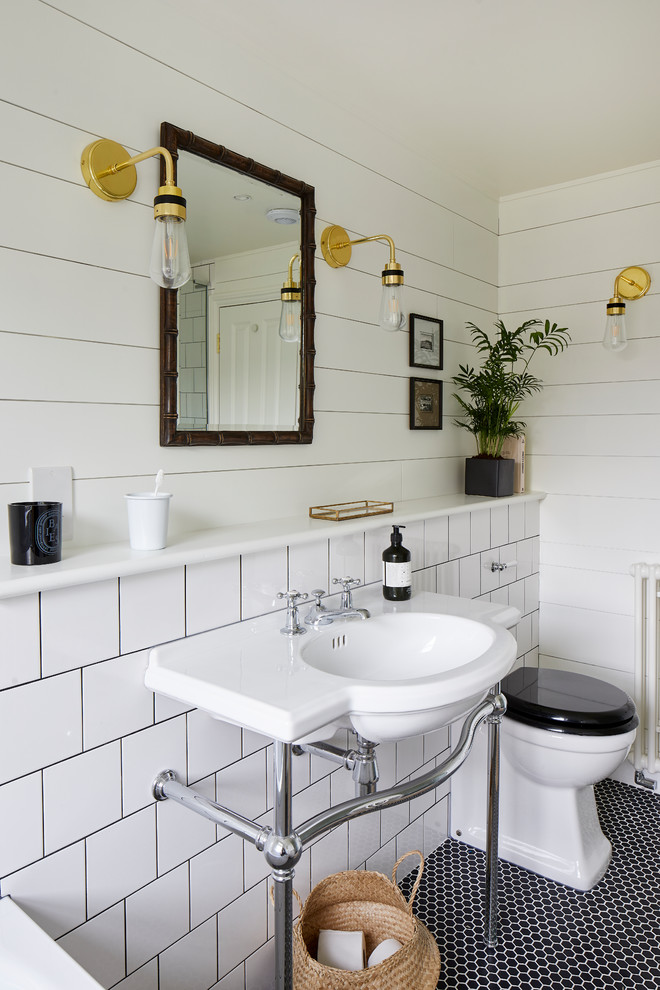 Immagine di una stanza da bagno bohémian con piastrelle bianche, pareti bianche, pavimento con piastrelle a mosaico, lavabo a consolle e pavimento nero