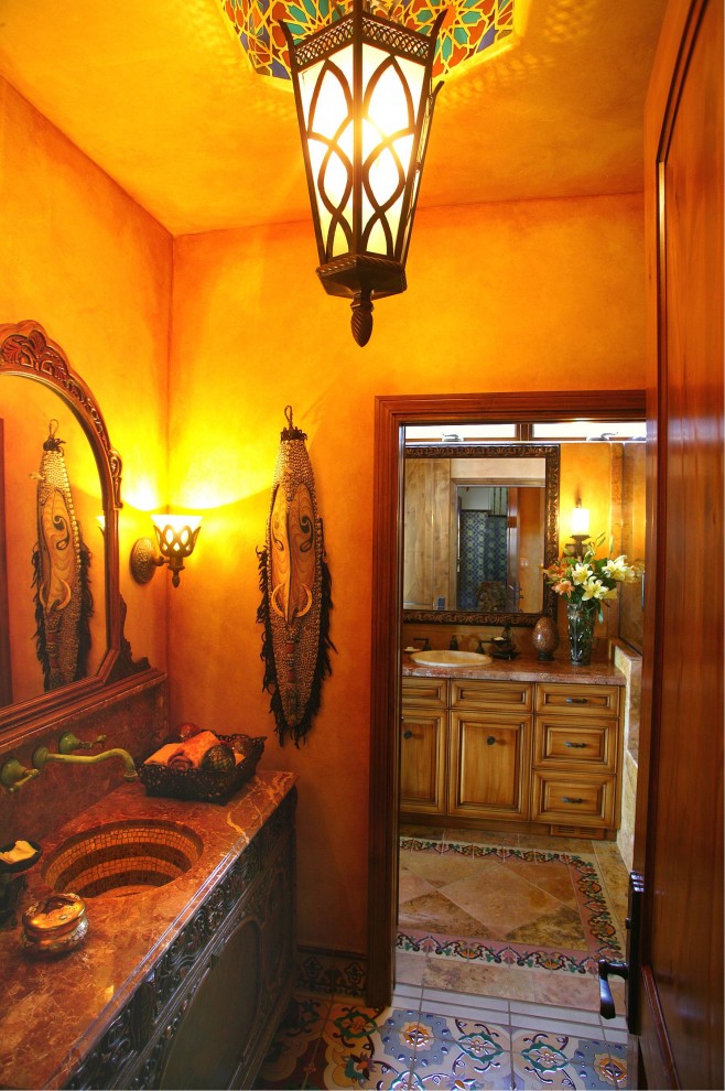 Ejemplo de cuarto de baño ecléctico con lavabo integrado, armarios con paneles con relieve y puertas de armario de madera oscura