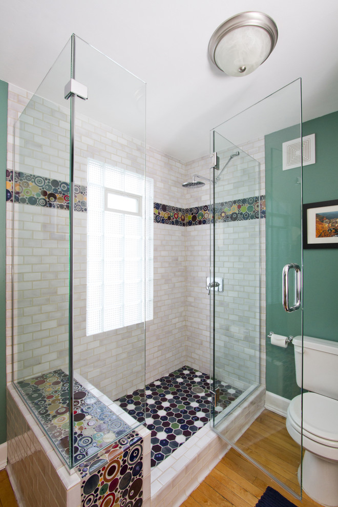 Photo of a medium sized bohemian shower room bathroom in Minneapolis with recessed-panel cabinets, light wood cabinets, wooden worktops, a corner shower, multi-coloured tiles, ceramic tiles, green walls, light hardwood flooring, a two-piece toilet, brown floors and a hinged door.