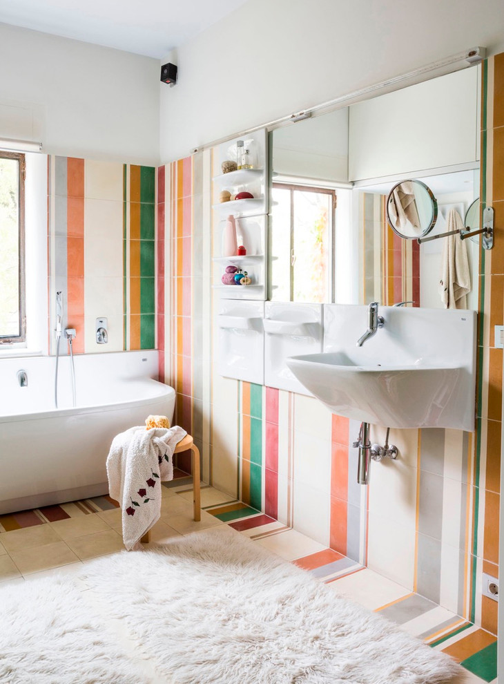 Cette photo montre une grande salle de bain principale éclectique avec un lavabo suspendu, un mur multicolore, une baignoire posée, un combiné douche/baignoire, un carrelage multicolore, des carreaux de céramique et un sol en carrelage de céramique.
