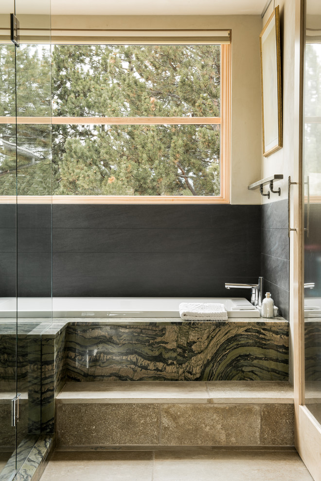 Ispirazione per una stanza da bagno minimal con vasca da incasso, piastrelle grigie e pareti beige