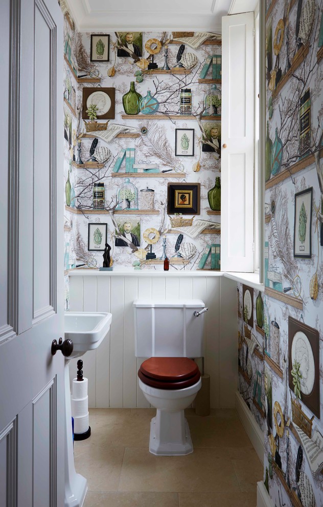 На фото: маленький туалет в стиле фьюжн с унитазом-моноблоком, разноцветными стенами и полом из известняка для на участке и в саду с