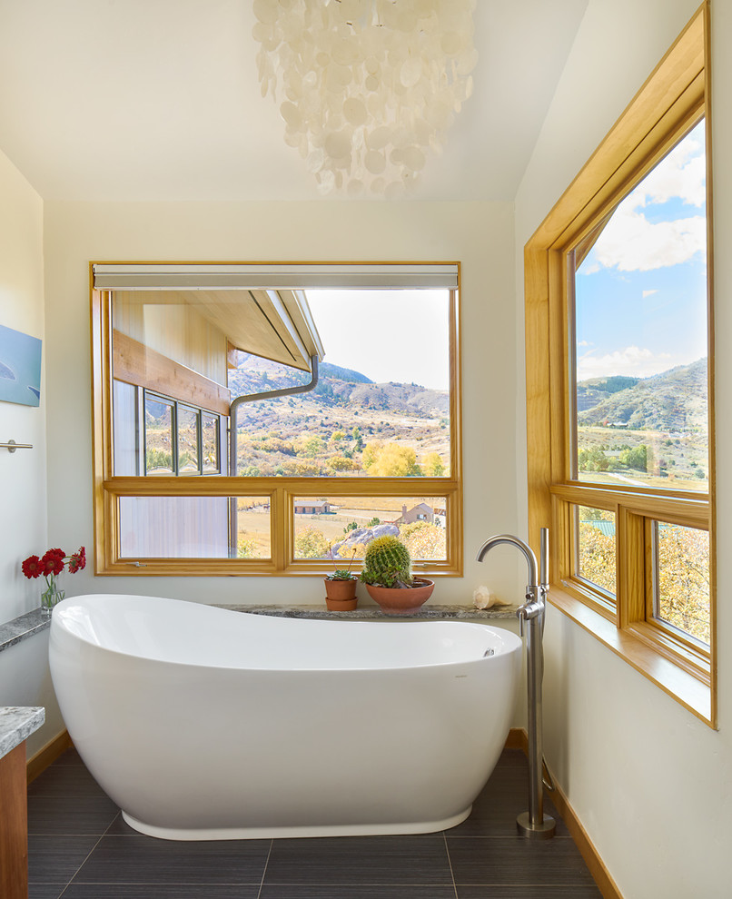 Foto de cuarto de baño principal contemporáneo grande con bañera exenta, suelo de baldosas de porcelana y paredes beige